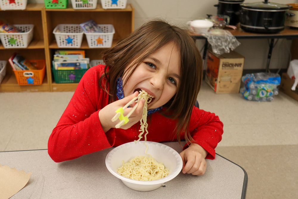 Elementary girl eating Ramen Noodles