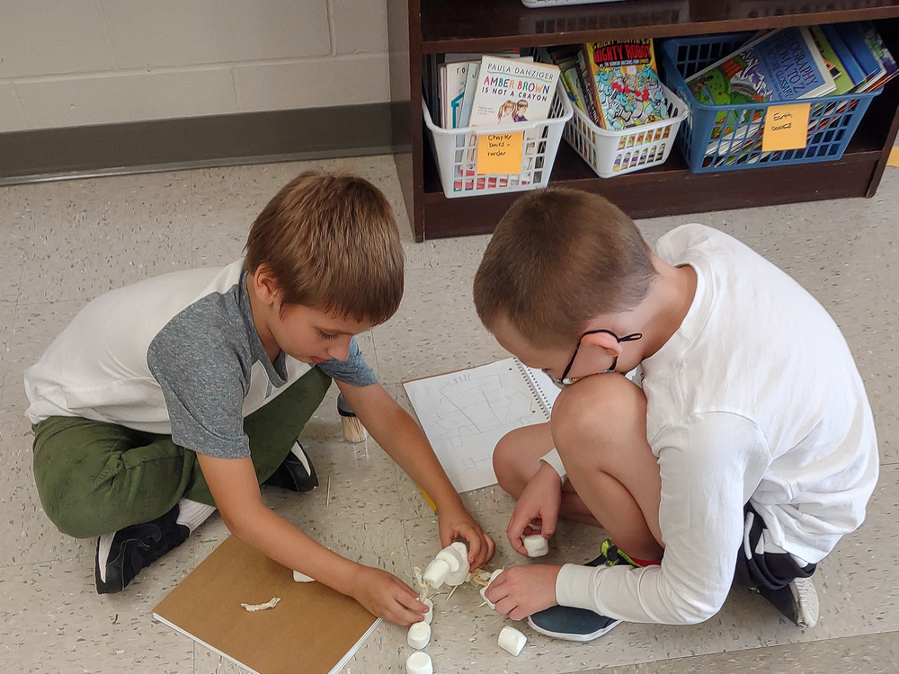 Two elementary students creating marshmallow structure