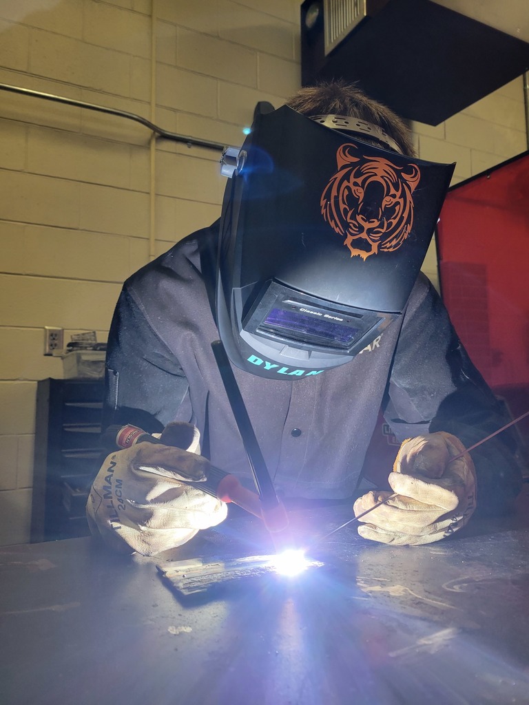 Student TIG welding with a tiger welding hood